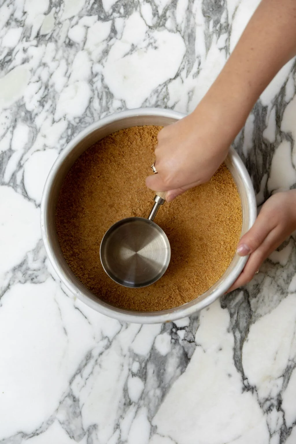 pressing the graham cracker crust into the pan