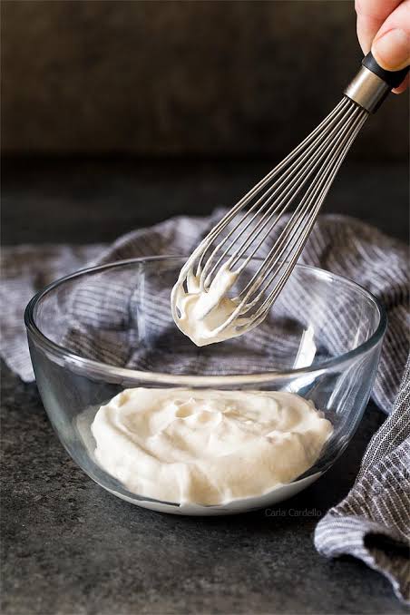 whipped cream on a whisk in a mixing bowl